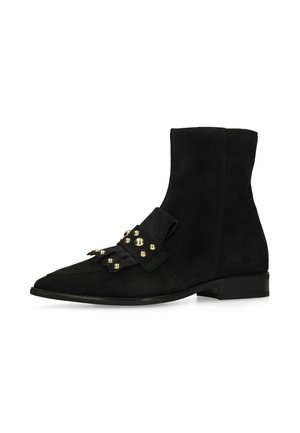 Black suede ankle boot with flat heel, pointed toe, and decorative strap featuring gold round studs across the front.
