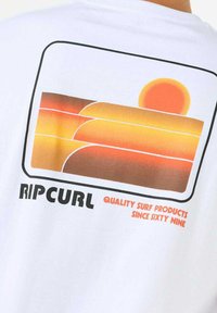 White t-shirt featuring a colorful sunset graphic in orange and yellow hues, with a black outline and "RIP CURL" text in bold.