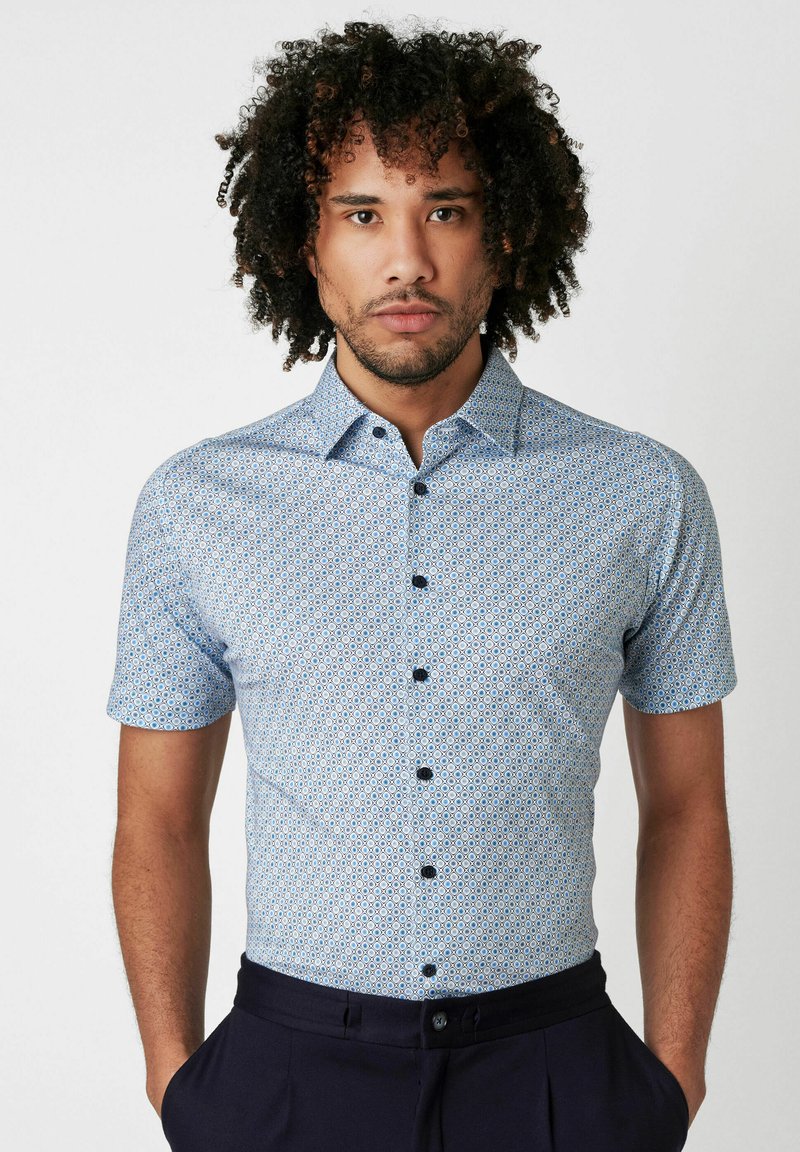 Kurzärmliges Button-Up-Hemd in Hellblau mit geometrischem Muster, ausgestattet mit einem Kragen und dunklen Knöpfen. Glatte Stoffstruktur.