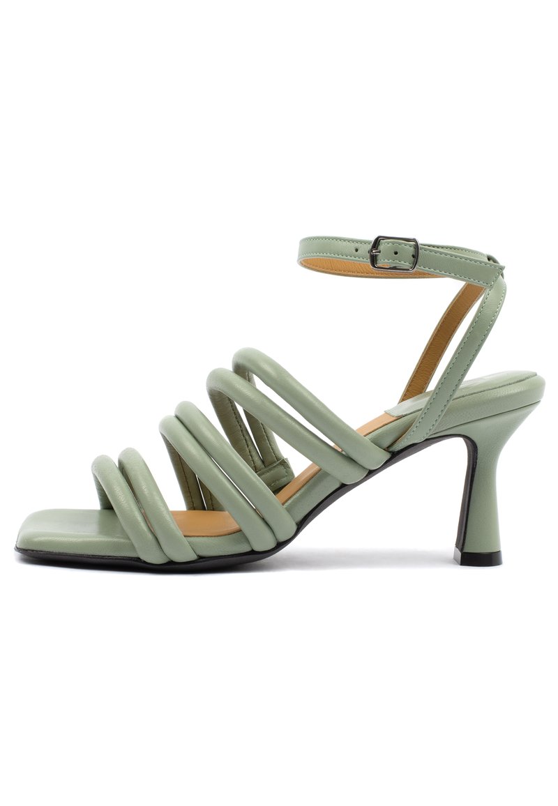Sandali con tacco in pelle verde con molteplici cinturini spessi, punta aperta e cinturino alla caviglia. Punta quadrata e tacco affusolato. Texture liscia.
