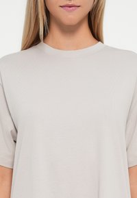 Light gray t-shirt featuring a crew neckline and short sleeves, crafted from soft cotton fabric with a smooth texture.