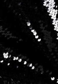 Zwart fabric bedekt met overlappende zwarte en zilveren pailletten die licht weerkaatsen, met een gladde, glanzende textuur en een uniek cirkelvormig patroon.