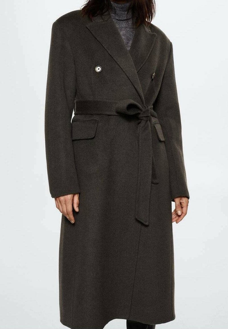 Manteau gris foncé à double boutonnage en laine, doté d'une ceinture nouée à la taille, de deux poches latérales et de revers crantés.