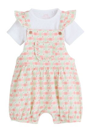 Biała koszula z krótkim rękawem z ażurowym wzorem pod różowym i jasnooliwkowym romperem w kratę z falbanianą kieszenią i ramiączkami.