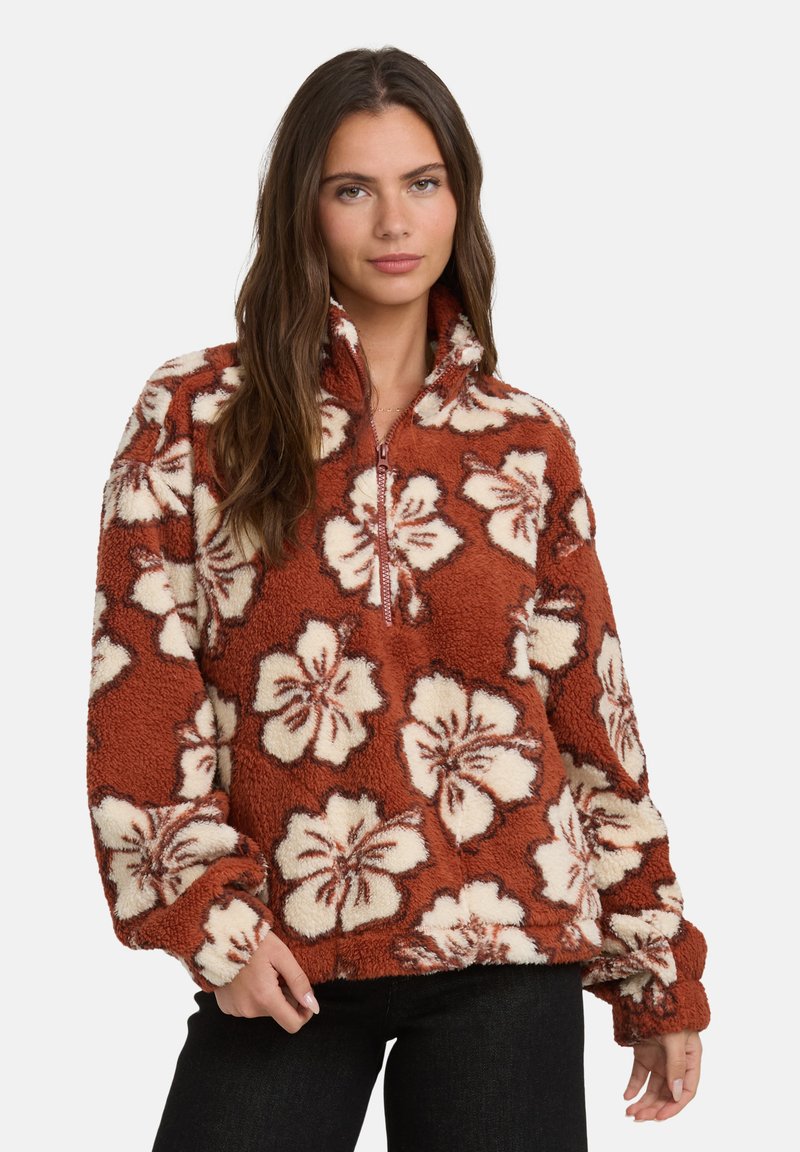 Pullover in pile color ruggine con motivo floreale hibiscus in crema, colletto a mezza zip e maniche lunghe. Tessuto morbido e testurizzato con vestibilità rilassata.