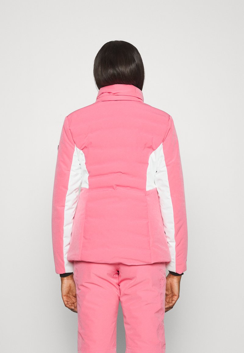 Roze gewatteerde jas met witte zijpanelen, hoge kraag en een getailleerde silhouette. Gladde textuur en zichtbare stikseldetails op de achterkant.