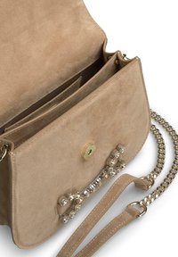 Bolso de ante beige con solapa plegable, herrajes dorados, adornado con strass transparentes, con una correa de cadena y compartimentos interiores.