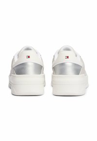 Białe sneakersy z metalicznym, srebrnym tylnym panelem i małym detalem z logo. Gumowe podeszwy z teksturowanym gripem. Minimalistyczny design.