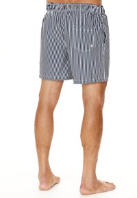 Marinefarbene und weiße gestreifte Badeshorts mit einem elastischen Bund, Seitentaschen und einer Gesäßtasche mit Klappe. Aus leichtem Stoff gefertigt.