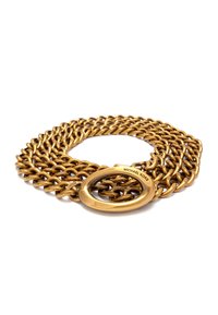 Gouden kettingriem met vergrendelde schakels, voorzien van een gladde ovale gesp met de gegraveerde tekst "MICHAEL KORS." Glanzende, metalen afwerking.