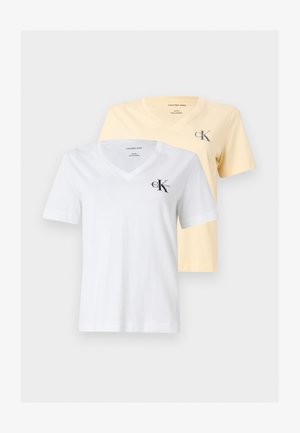 Dwie koszulki Calvin Klein Jeans z dekoltem w serek, jedna biała i jedna jasnżółta, każda z małym logo CK na lewej piersi.