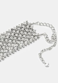 Silberarmband mit einem Mesh-Design, geschmückt mit zahlreichen klaren Strasssteinen, gesichert mit einer Kette und einem Karabinerverschluss.