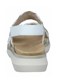 White braided sandals with a wide strap, soft footbed, and a chunky white outsole. Smooth leather texture with a neutral sole.