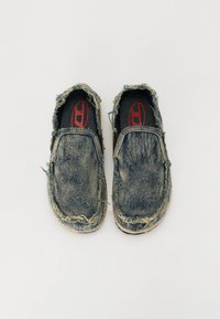 Denim slip-on shoes with a frayed edge, blue-gray color, textured surface, black interior, and a red logo on the inner sole.