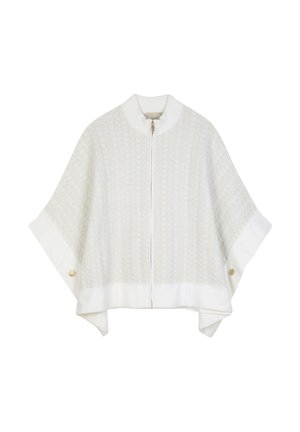 Cape blanche en maille avec fermeture éclair à l'avant, manches larges, et détails de boutons dorés près des poignets.