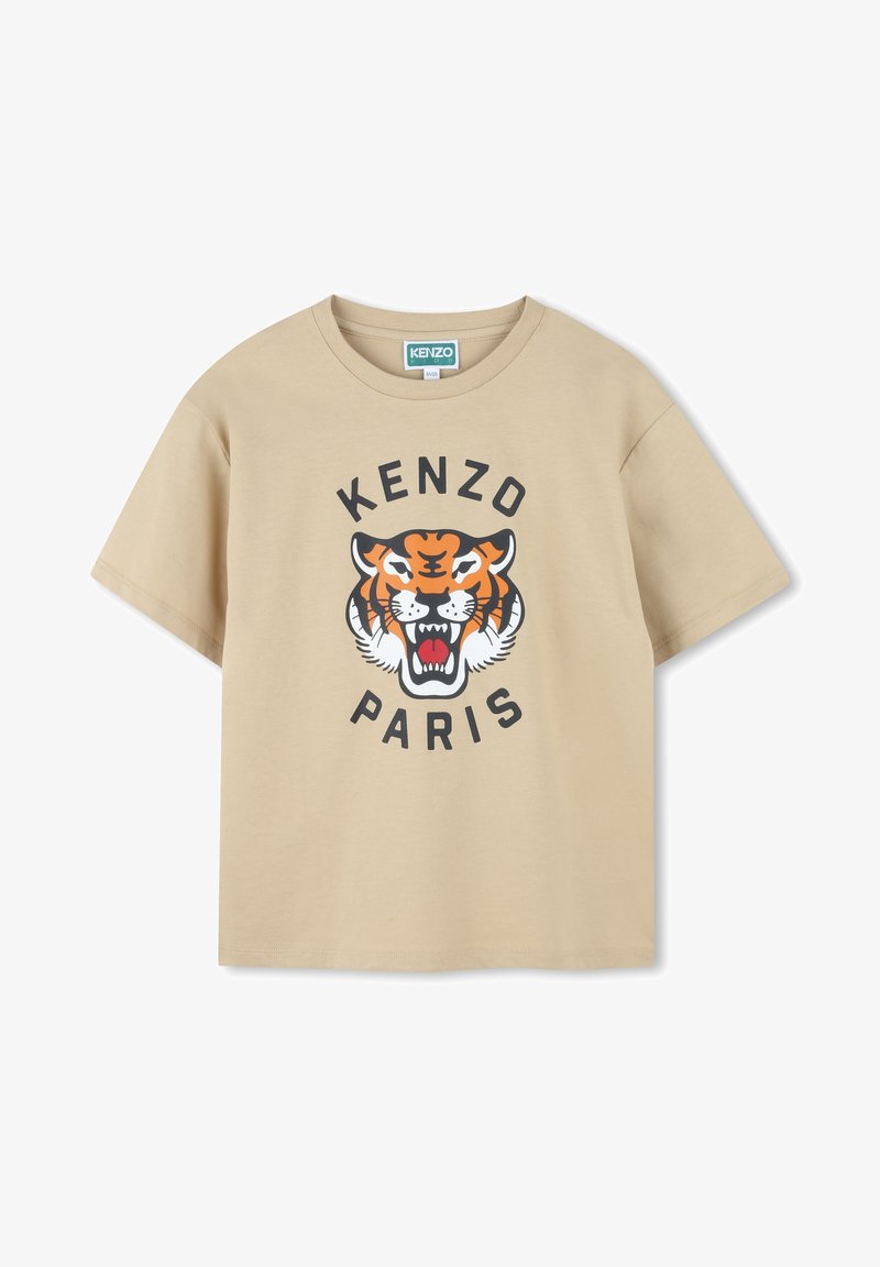 T-shirt in cotone beige con una grafica di una tigre in arancione e nero, con "KENZO" sopra e "PARIS" sotto in grassetto nero. Maniche corte.