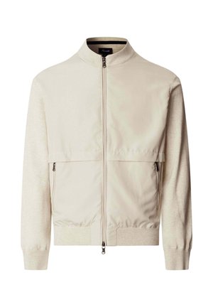 Chaqueta beige con cremallera, con cuello, puños y dobladillo acanalados, que cuenta con dos bolsillos frontales con cremallera y un panel de tela lisa en el pecho.