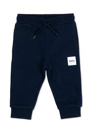 Pantaloni della tuta blu navy per bambino piccolo con elastico in vita, coulisse, polsini a coste e una toppa quadrata bianca con la scritta "BOSS" sulla gamba destra.