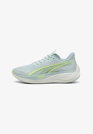Baskets de course bleu clair avec une tige en mesh respirant, une semelle intermédiaire blanche, des accents verts et une semelle texturée pour l'adhérence.