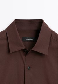 Brun button-up skjorte med spidse kraver, udstyret med en sort knap, glat stofstruktur og et synligt brandmærke, Massimo Dutti.