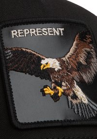 Schwarzes Kappenpatch mit gesticktem fliegendem Adler und dem Wort "REPRESENT" in Weiß über dem Adler.