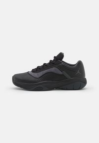 Scarpa sportiva nera dal design elegante, con materiali in pelle e mesh, pannelli laterali texturizzati e suola in gomma con scanalature per la presa.