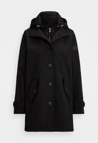 Manteau noir imperméable avec capuche, doté d'une fermeture à double boutonnage, de deux poches latérales et d'un écusson avec logo sur la manche.