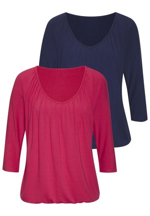 Twee driekwart mouw tops in donker marineblauw en roze. Met een ronde halslijn, gathered details bij de buste en zachte, rekbare stof.