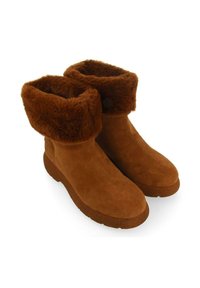 Botines de ante marrón con un suave forro de piel de oveja en el puño, punta redondeada y suela de goma texturizada. Diseño sencillo y altura modesta.