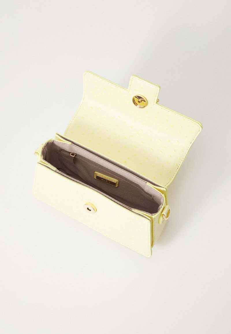 Portefeuille en simili cuir jaune avec une surface texturée, fermeture à pression, et un intérieur en tissu beige comprenant un emplacement pour cartes et une poche zippée.