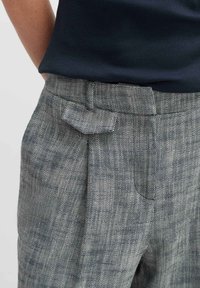 Grijze geruite broek met een gladde textuur, voorzien van een platte tailleband, zijzakken en een subtiele schuine details aan de voorkant.