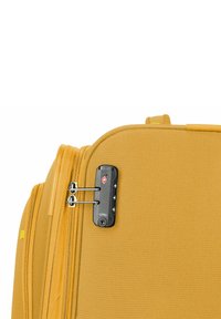 Gelbe weiche Reisetasche mit einem strukturierten Stoffaußenmaterial, Reißverschluss und einem TSA-zugelassenen Schlossmechanismus.