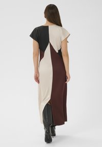 Rochie maxi color-block, cu panouri negre, crem și burgund, mâneci scurte, fanta laterală și textură netedă a țesăturii.