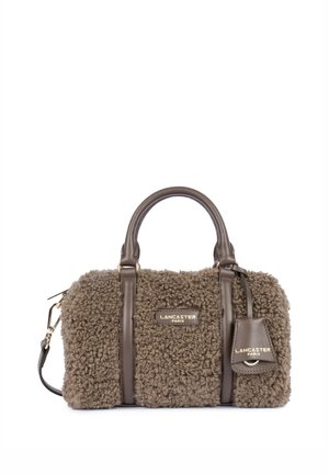 Sac à main marron en fausse fourrure texturée avec poignées et détails en cuir, garnitures dorées, et logo Lancaster Paris à l'avant et sur l'étiquette.
