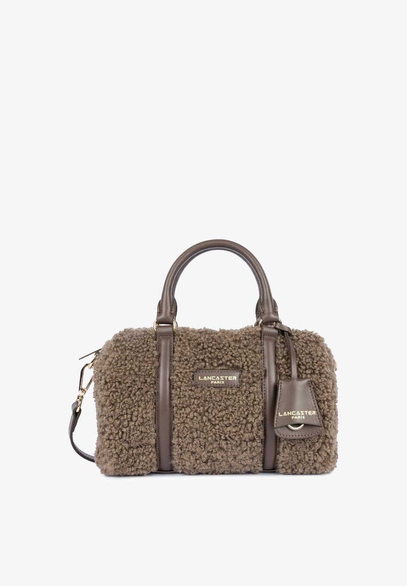 Sac à main marron en fausse fourrure texturée avec poignées et détails en cuir, garnitures dorées, et logo Lancaster Paris à l'avant et sur l'étiquette.