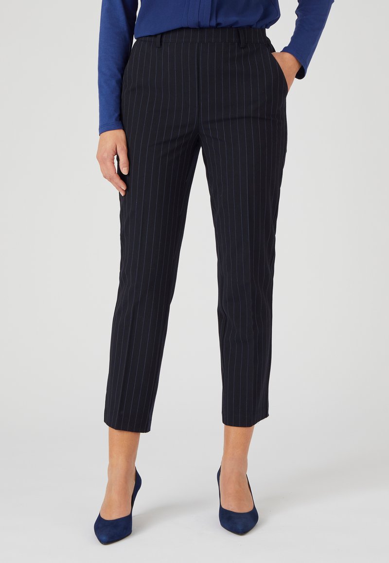Marineblauwe pinstriped broek met een op maat gemaakte pasvorm, voorzien van een gladde textuur, taps toelopende benen en een middelhoog tailleband, gecombineerd met marineblauwe hakken.