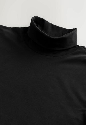 Melnas turtlenecks blūzes, kas izgatavota no mīksta, elastīga auduma. Tam ir augsts apkakle un gluda tekstūra, un tā ir veidota ar garām piedurknēm.