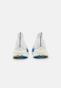 Scarpe da ginnastica bianche con tomaia in maglia, caratterizzate da accenti blu e verdi sulla suola. Texture liscia e un pratico pull tab per indossarle facilmente.