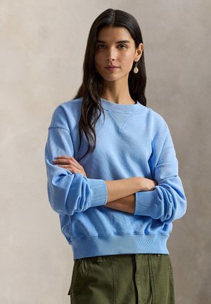 Felpa di cotone azzurro chiaro con scollo rotondo, polsini e orlo a costine. Caratterizzata da una vestibilità comoda e una texture morbida.