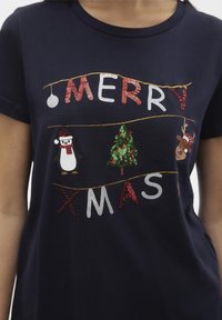 Námořnické bavlněné tričko s nápisem "ŠŤASTNÉ VÁNOCE" v multicolor flitrových písmenech, s ilustracemi tučňáka, soba a vánočního stromečku.