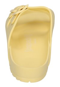 Gelbe Slipperschuhe aus glattem, gummiähnlichem Material. Verfügt über ein strukturiertes Fußbett und ein dekoratives Twist-Element am Riemen.