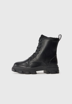 Black leather ankle boots with a chunky rubber sole, lace-up front, and soft fur lining at the top. Features pull tab for easy wear.