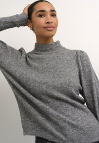 Szürke, magas nyakú pulóver puha, texturált anyagból, laza szabással és bordás aljjal. Hosszú ujjú, enyhe puffrészlet a vállaknál.