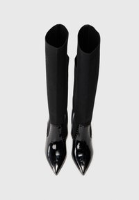 Black patent leather ankle boots with pointed toes and ribbed fabric shafts. Features a sleek design with no visible hardware or patterns.