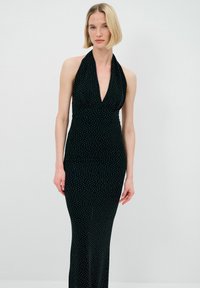 Schwarzes Halterneck-Kleid mit tiefem V-Ausschnitt, taillierter Silhouette und silbernem Punkte-Muster. Hergestellt aus glattem, elastischem Stoff.