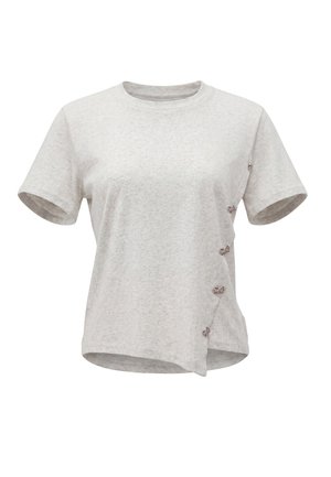 T-shirt grigia chiara a maniche corte con scollo rotondo e piccoli bottoni decorativi a forma di farfalla lungo una cucitura diagonale sul lato destro anteriore.