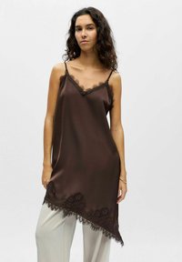 Camisole en satin marron avec bordure en dentelle au niveau de l'encolure et de l'ourlet, dotée de bretelles réglables et d'une coupe décontractée.