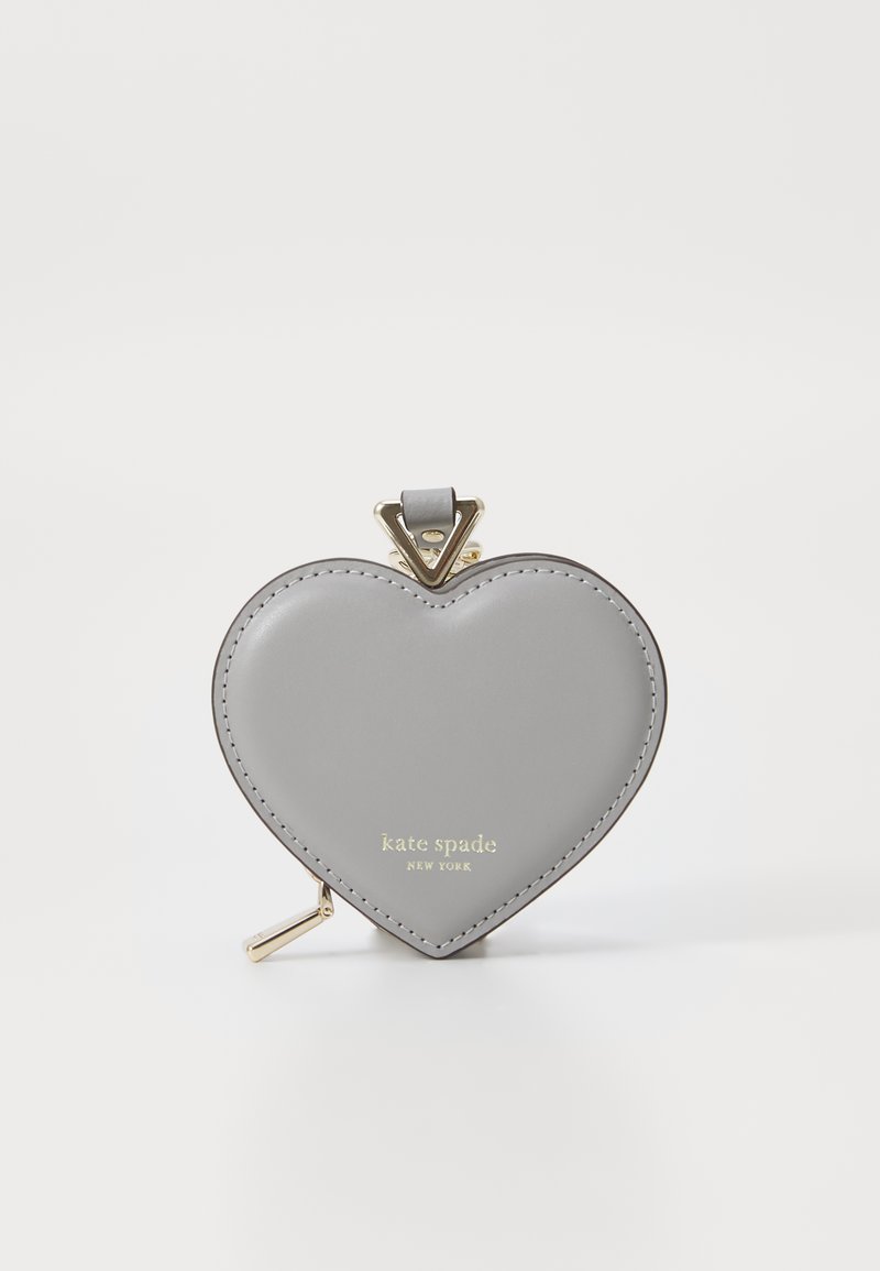 Portafoglio a forma di cuore grigio realizzato in pelle con hardware dorato e logo impresso. Il design presenta una texture liscia e una chiusura a scatto.