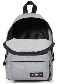 Grå tygryggsäck med klaffstängning, framficka, justerbara axelremmar och svart inredning. Har Eastpak-logotypen på framsidan.