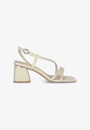 Beige hakken sandaaltjes met dunne bandjes, vierkante neus en een blokhak. De hak heeft een metallic accent en het materiaal is glad en gepolijst.